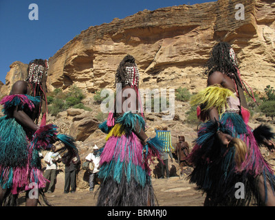 Dogon Tänzer tragen Masken und langen bunten Stroh Röcke ein zeremonieller Tanz Stockfoto