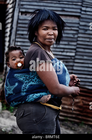 Xhosa-Frau, die ihr Kind auf dem Rücken in eine Decke gehüllt. Stockfoto