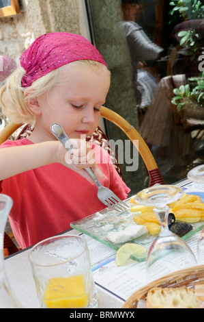 Stock Foto von einem vier Jahre alten Mädchen einen Teller mit Fish &amp; Chips in einem Restaurant zu genießen. Stockfoto