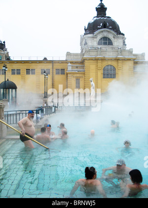 Dampfenden täglich bei der thermischen Szechenyi Bad Budapest Ungarn, an einem verschneiten Neujahr mit Schachspieler sichtbar im Zentrum. Stockfoto