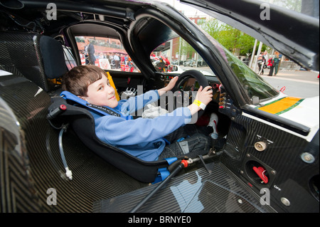 Kleiner Junge sitzt im Jaguar F1 Sportwagen LeMans voll Modell veröffentlicht Stockfoto