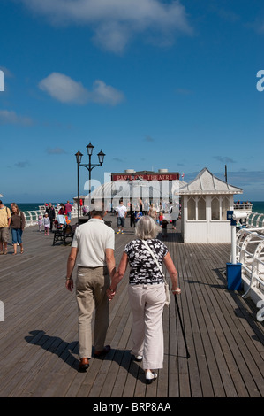 Älteres Ehepaar zu Fuß entlang Cromer Pier an einem Sommertag in Norfolk, East Anglia, England. Stockfoto