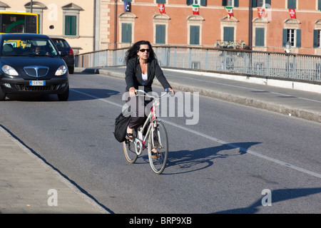 Weibliche Radsportler, die Brücke über den Fluss Arno, Pisa, Italien Stockfoto