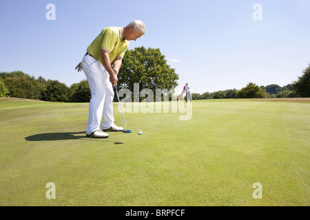 Caddy zeigt auf ein Loch am Golfplatz Stockfoto