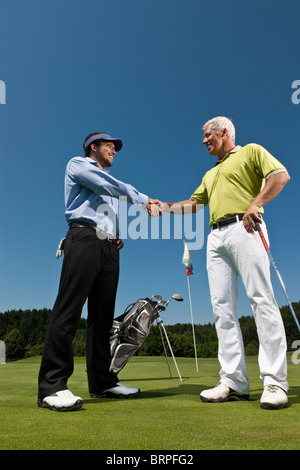 Golfer und Caddy Händeschütteln Stockfoto
