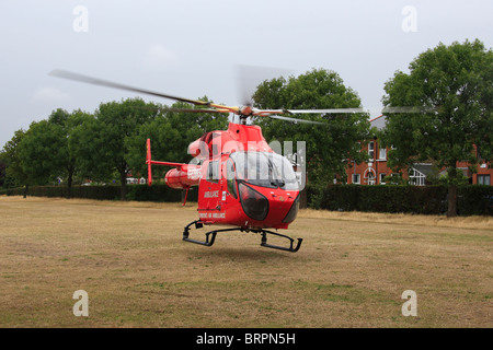 G-EHMS verwendet ein Spielfeld in einem Londoner Park als einen Landeplatz, während Besucher auf einen Unfall in einer nahe gelegenen Residenz. Stockfoto