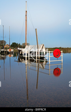 Springflut Überlaufen der Hafenmauer mit Reflexionen an Blakeney, Norfolk, England, Vereinigtes Königreich. Stockfoto