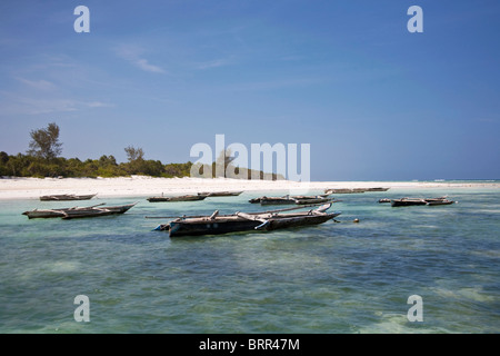 Strand-Szene mit Ausleger Angelboote/Fischerboote vertäut im seichten Wasser vor Mnemba Island Stockfoto