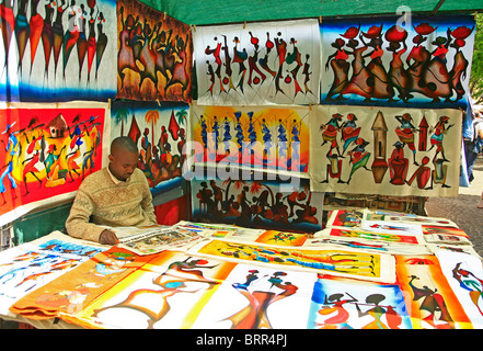 Kreditor Zeitunglesen in seinem Stall zu verkaufen afrikanische Gemälde. Stockfoto