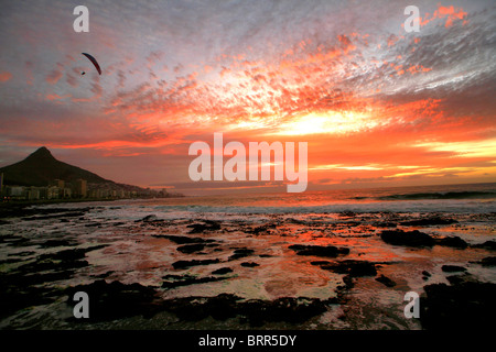 Moody-Blick über Sea Point am Strand bei Sonnenuntergang, dramatische Wolken mit dem Gleitschirm über den Atlantischen Ozean Stockfoto