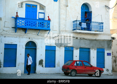 Mann zu Fuß vorbei an einem Gebäude mit charakteristischen blau-weißen Architektur Stockfoto