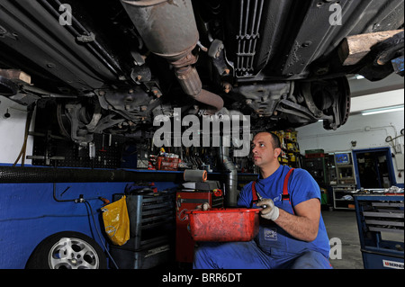 Kfz-Werkstatt mit Mechaniker bei der Arbeit. Stockfoto