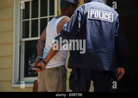 Mann während einer Drogenrazzia von Detroit Polizei Betäubungsmittel Polizisten mit Handschellen gefesselt. Stockfoto