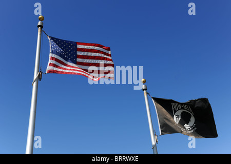 Die Vereinigten Staaten der amerikanischen Flagge fliegt neben schwarzen POW/MIA Flagge über blauen Himmel Stockfoto
