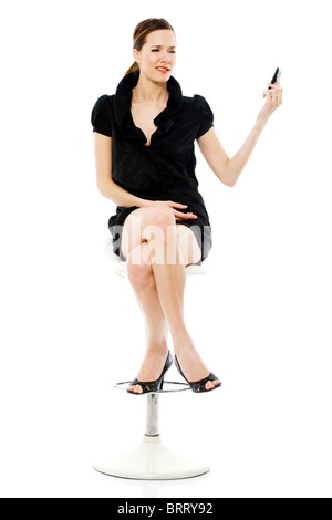 elegante junge Frau sitzt auf einem Stuhl halten eines Handys Stockfoto