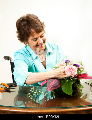 Ziemlich behinderte Frau einen Blumenstrauß arrangieren. Stockfoto