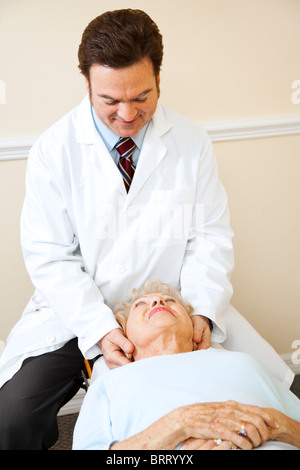 Freundlichen Chiropraktiker passt ein senior Woman Halswirbelsäule (Hals). Stockfoto