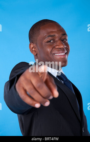 Glücklich afrikanischen Geschäftsmann zeigt Ihnen mit einem blauen Hintergrund Stockfoto