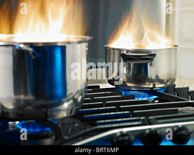 Pfannen in Feuer auf einem Herd. Horizontale Form Stockfoto