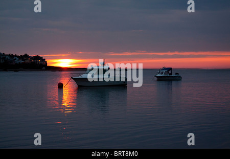 Boote in einem ruhigen Meer bei Sonnenuntergang an instow Beach North Devon UK gegen Appledore Stockfoto