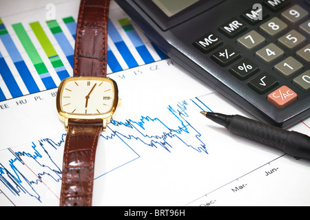 Drucken Sie aus finanziellen Graphen mit einem Taschenrechner, Kugelschreiber und eine Uhr. Stockfoto