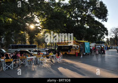 Sonne durch die Bäume auf Menschen, die Essen an einem mobilen "Parilla Mi Sueno My Dreams" Grill, Costanera Sur Boulevard, Buenos Aires Stockfoto