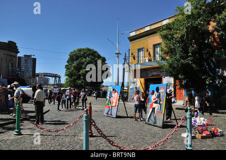 Leute standen um Tango-Themen Ausschnitte auf dem Kopfsteinpflaster am Riverwalk, südlichen Ende Caminito, La Boca, Buenos Aires Stockfoto