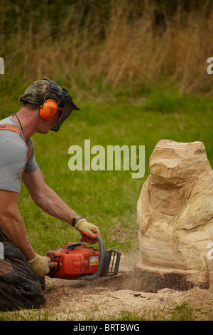 Woodland Handwerker schnitzen ein Bär Statue mit einer Kettensäge. Stockfoto