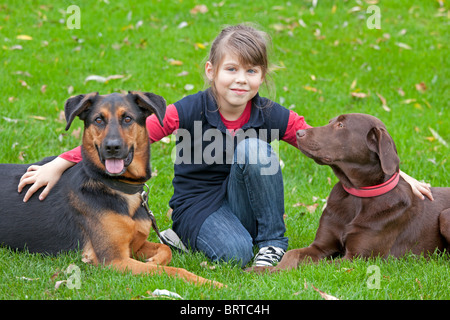 Porträt eines jungen Mädchens hockend zwischen ihren Hunden Stockfoto