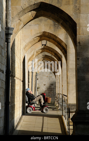 Behinderung-Benutzer-Rampe für Zugang und Eingang in Winchester Kathedrale Mann ruht im Sonnenlicht auf ein Elektromobil Stockfoto