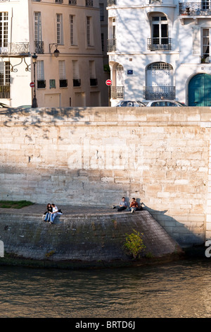 ein umwerben paar & 2 junge Männer teilen einen Sandwich genießen Sie späte Nachmittagssonne am Quai d ' Orléans auf warmen Herbstnachmittag in Paris Stockfoto