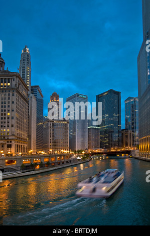 Skyline von Chicago und Wolkenkratzer in der Nacht mit River Tour Boot am Chicago River, Chicago USA Stockfoto