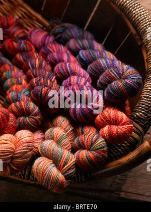 Bunte Knäuel handgefärbte Wolle Garn für handgestrickt Pullover in rustikalen Weidenkorb. Stockfoto