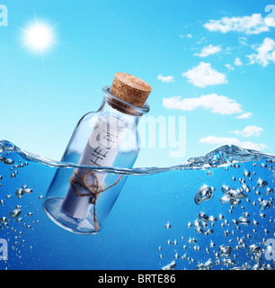 Flasche mit Hilfemeldung schwebend in die Wellen sehen. Stockfoto