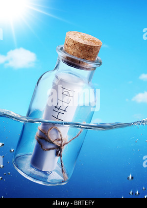 Flasche mit Hilfemeldung schwebend in die Wellen sehen. Stockfoto