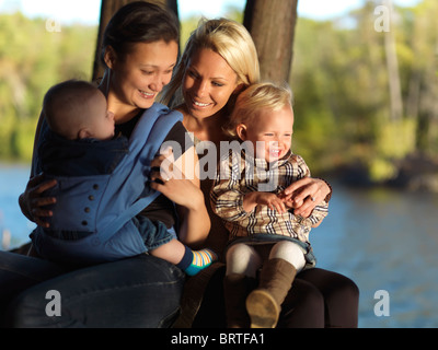 Zwei junge Mütter mit ihren Kindern genießen ihre Zeit in der Natur. Ontario, Kanada. Stockfoto