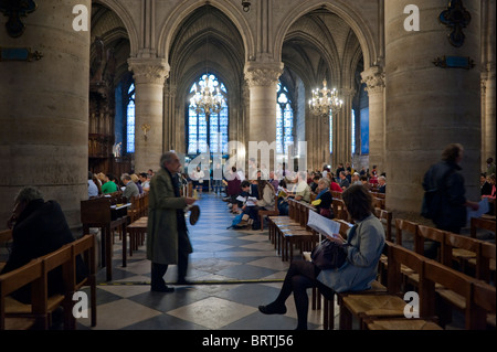 Paris, Frankreich - Menschen beten bei der traditionellen katholischen Messe, innerhalb der französischen katholischen Kirche 'Notre Dame Kathedrale' Innenräume, innerhalb der Kirche, europäische religiöse Praxis Stockfoto