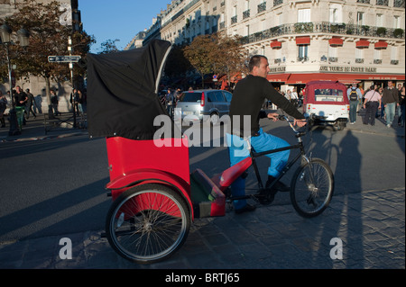 Paris, Frankreich, Mann fahren Tourist Taxi Rikscha auf Straße, vor der Kathedrale Notre-Dame Stockfoto