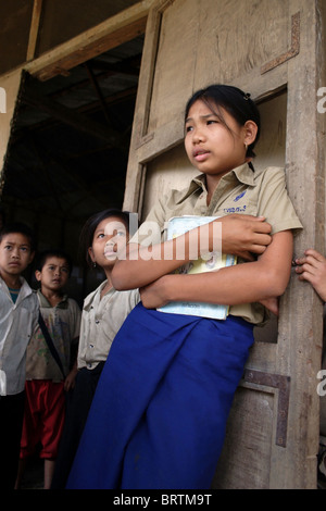 Eine 13-jährige Schüler der 6. Klasse, (vorne) hält ihre Schulbücher an The Ban Buamlao Primary School in Ban Buamlao, Laos. Stockfoto
