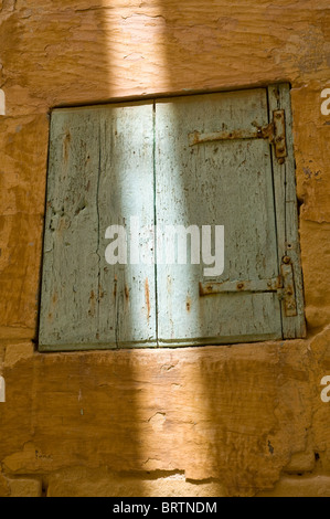 Alte blaue Tür gelbe Wand mit Schatten in einer engen Straße in Victoria Gozo Malta Stockfoto