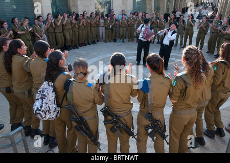 eine Gruppe von weiblichen Soldaten Dansing zu den Klängen von zwei Klezmer-Musiker im Rahmen ihres Besuchs in Jerusalem Stockfoto