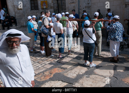 Pilger, die den Weg des Kreuzes trägt ein hölzernes Kreuz. Altstadt von Jerusalem Stockfoto