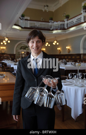 Kellnerin halten Gläser in der hand vor einem Speisesaal im Restaurant des Curia Palace Hotel, Kurie, Portugal Stockfoto