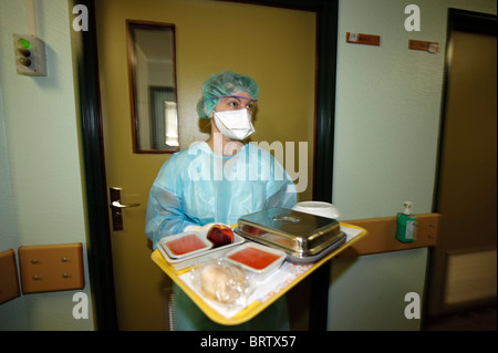 Gesundheitsfachkraft mit Schutzmaske trägt ein Tablett mit Mahlzeiten für die Patienten in einem Krankenhaus - Corona-Virus des Coronavirus Coronas Stockfoto