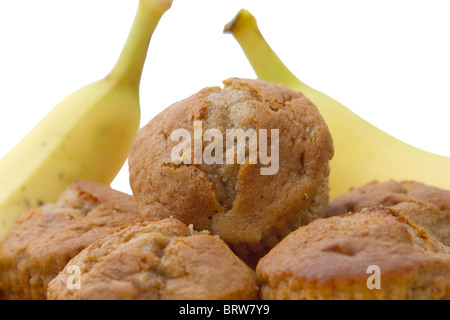 kleine Stapel von Bananen-Muffins mit Bananen im Hintergrund auf weiß Stockfoto