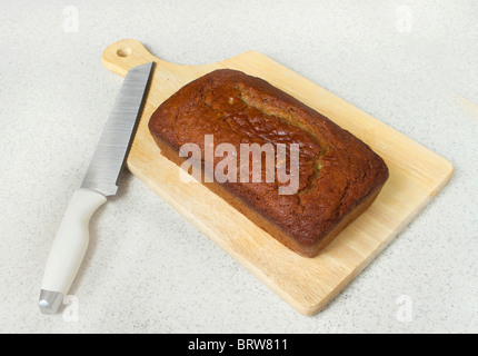 ein Brotlaib Banane auf ein Schneidebrett mit Messer auf einer Arbeitsplatte Stockfoto