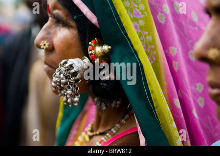 Eine sehr bunte indische Frau tragen traditionelle große silberne Ohrringe. Stockfoto