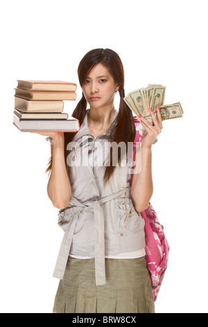 Asiatische Studentin mit Rucksack Gleichgewicht Haufen Bücher und Geld in ihren Händen mit großer Sorge Ausdruck Stockfoto