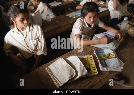 Ein Schüler zeigt den Zustand ihrer Lehrbücher und Arbeitsmappen an The Ban Buamlao Primary School in Ban Buamlao, Laos. Stockfoto