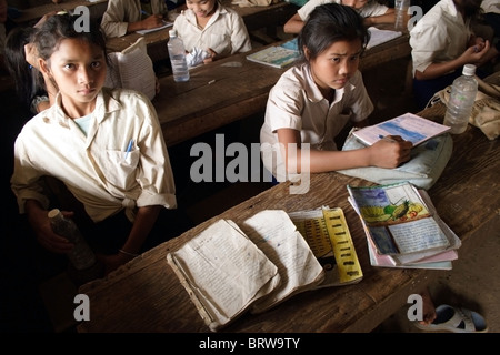 Ein Schüler zeigt den Zustand ihrer Lehrbücher und Arbeitsmappen an The Ban Buamlao Primary School in Ban Buamlao, Laos. Stockfoto